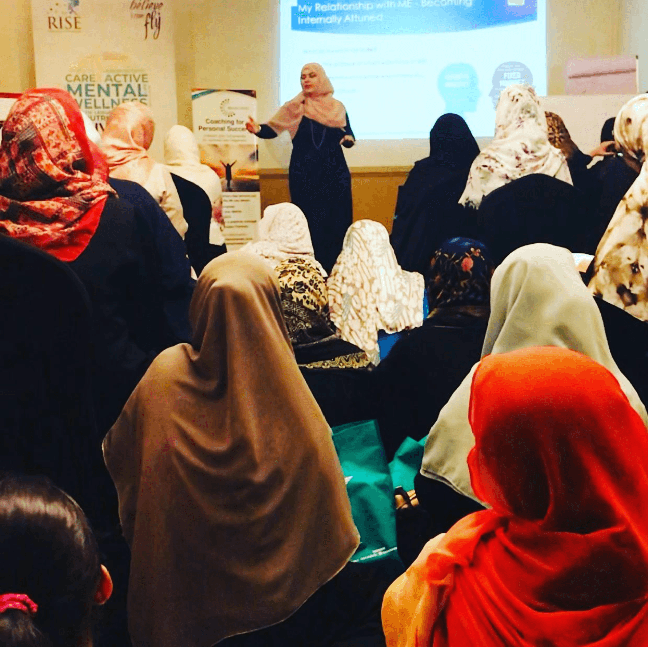 Marriam Ahmed speaking at RISE — packed room of women